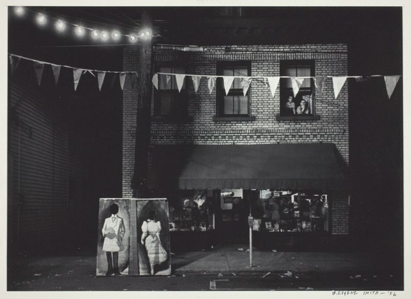 Untitled [night view, store front with pennants]